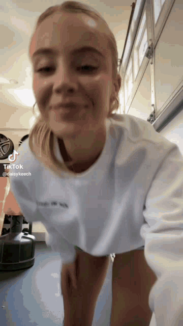 a woman wearing a white shirt with the word tiktok on the top