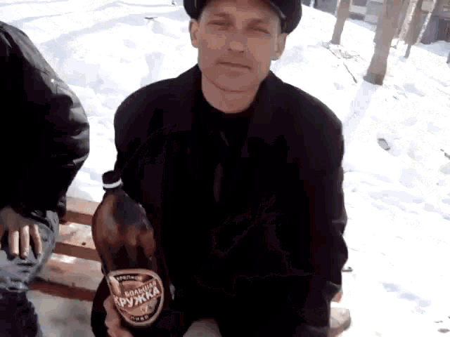 a man is kneeling down holding a large bottle of beer that says " лучшая дружка " on it