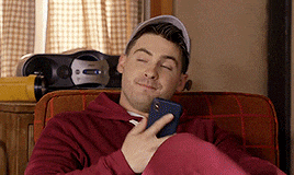 a man is sitting in a chair with his eyes closed and holding a cell phone