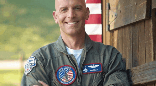a man wearing a military uniform has a patch on his jacket that says ' norman ' on it