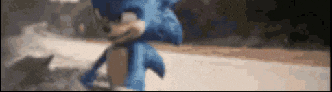 a blurry picture of a blue sonic the hedgehog running down a road .