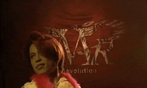 a woman singing into a microphone in front of a sign that says " t.m. gay "