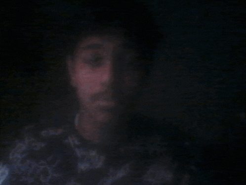 a blurry picture of a person 's face with a light coming out of their mouth