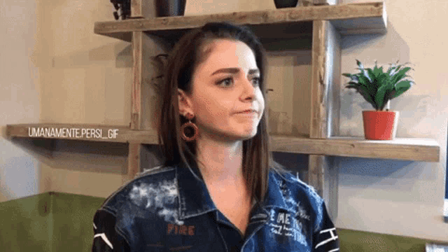 a woman wearing a denim jacket with the word fire written on it