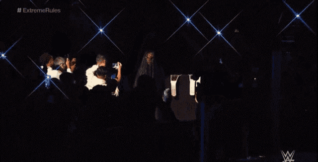 a person taking a picture of a wrestler in front of a sign that says #extremerules