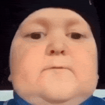 a close up of a child 's face with a hat on .