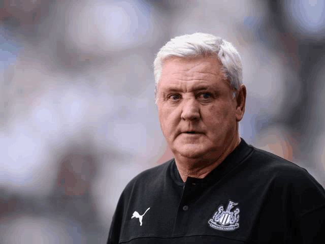 a man wearing a shirt that says ' newcastle united ' on the front