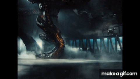 a giant monster is crawling through a dark room with smoke coming out of it .