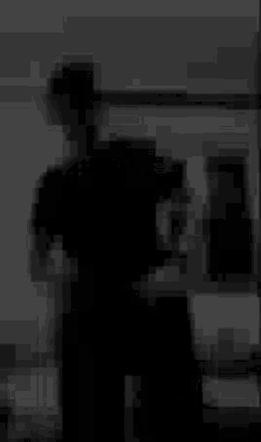 a blurry black and white photo of a person standing in a room .