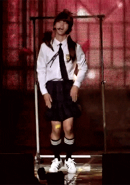 a man in a school uniform is dancing on stage