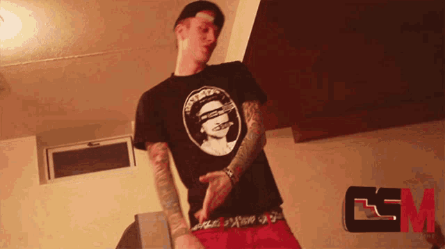 a man wearing a black shirt with a picture of a man on it dancing
