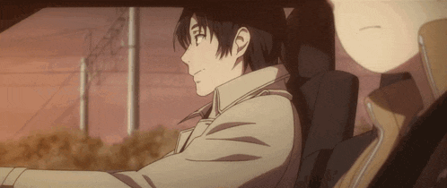 a man in a trench coat is sitting in a car with another man .