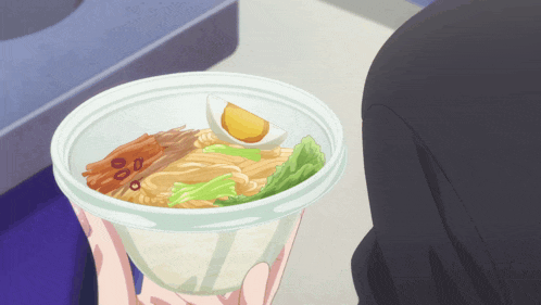a person is holding a bowl of ramen with a hard boiled egg