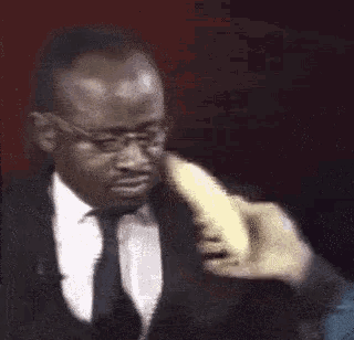 a man in a suit and tie with glasses looks at something