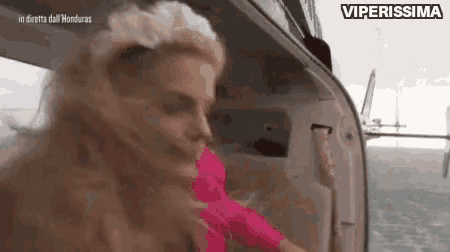 a woman is standing in the back of a helicopter with the words viperissima on the bottom .