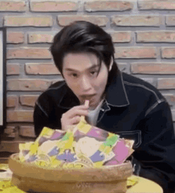 a man is sitting at a table eating a candy bar .