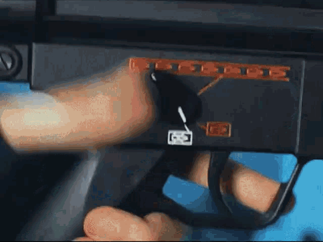 a close up of a person holding a gun with the letter d on the side