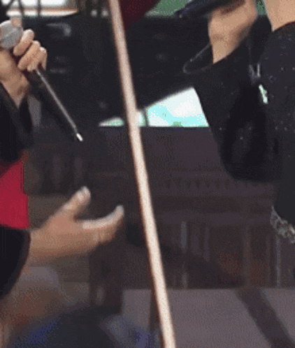 a close up of a person holding a microphone in their hands .