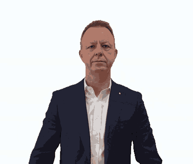 a man in a suit and white shirt making a heart shape with his hands