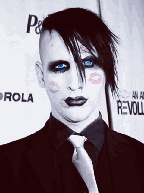 a man with lipstick on his face stands in front of a wall that says rola