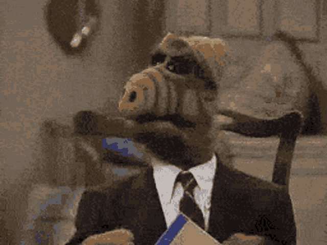 a monkey wearing a suit and tie is holding a piece of paper