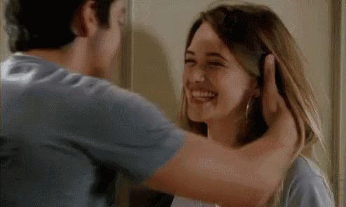 a man and a woman are hugging and laughing .