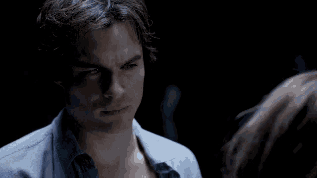 a woman in a plaid shirt looks at a man in a blue shirt