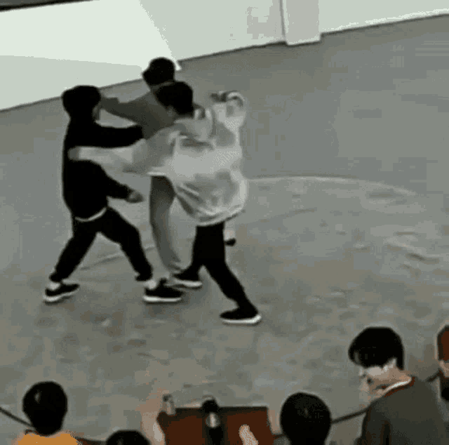 a group of people are standing on top of a concrete floor .