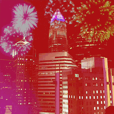fireworks are displayed over a city skyline with a building in the foreground that says ' chase bank ' on it