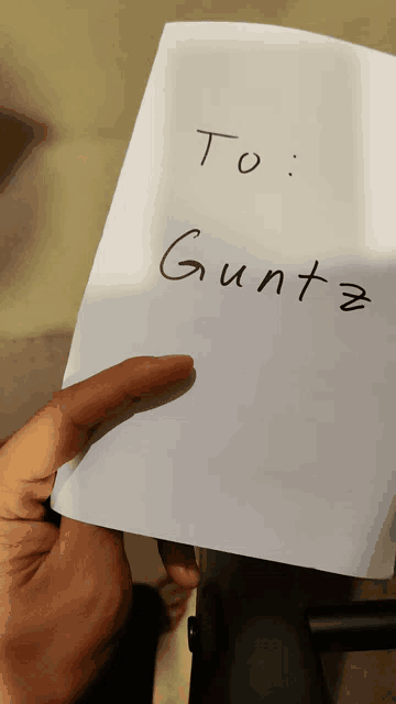 a person is holding a piece of paper that says to gunta