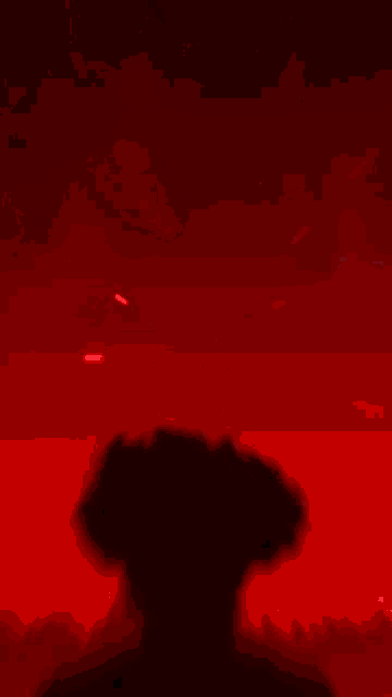 a silhouette of a person with red eyes is against a red background