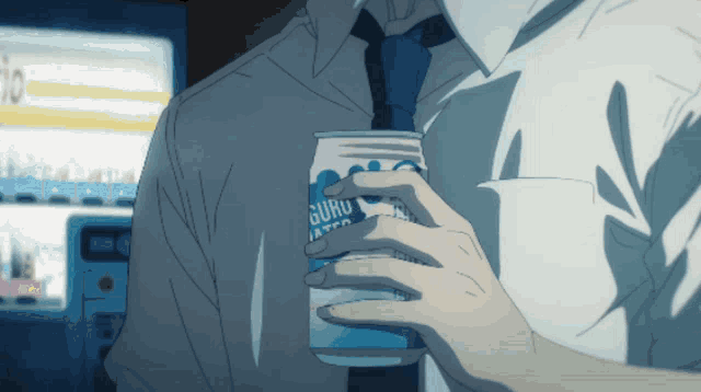 a man is holding a can of guru water in his hand