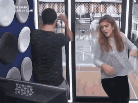 a man and a woman are dancing in front of a television .