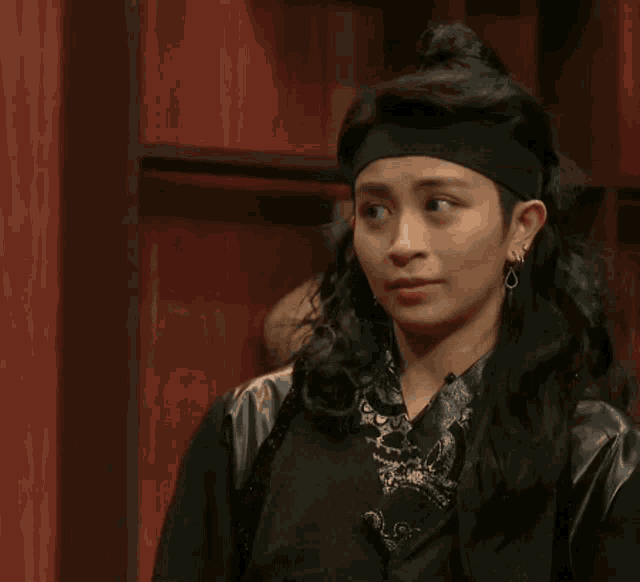 a woman wearing a headband and earrings is making a funny face with the words tien dau written below her