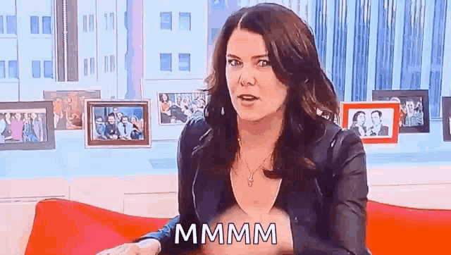 a woman is sitting on a couch and making a funny face while talking .