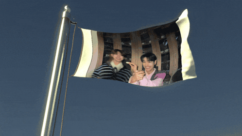 a flag with a picture of two men on it is flying in the wind