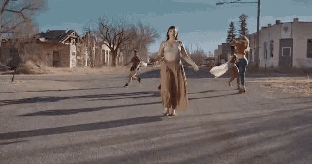 a group of people are dancing in a deserted street