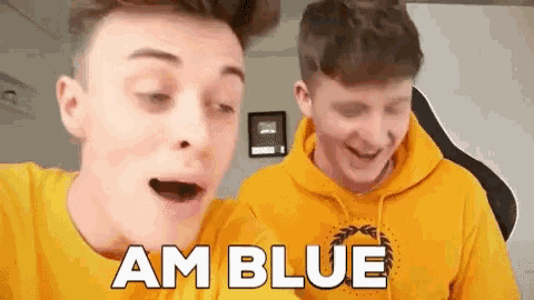 two young men wearing yellow hoodies are laughing and one of them is saying am blue .