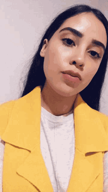 a woman wearing a yellow vest and a grey shirt