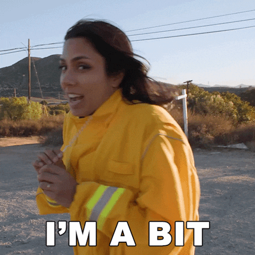 a woman in a yellow jacket says " i 'm a bit " in white letters