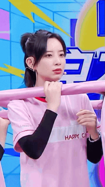 a woman wearing a pink shirt that says happy city