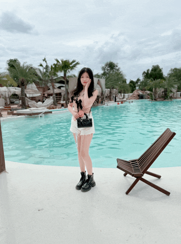 a woman standing in front of a large pool