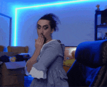 a woman in a blue dress is covering her mouth