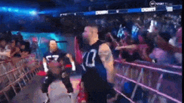 a man is standing in a wrestling ring with a crowd behind him .