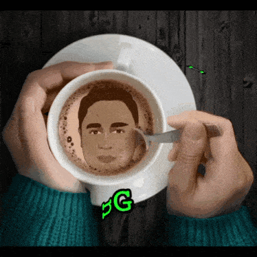 a cup of coffee with a man 's face drawn on it