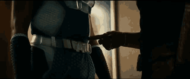 a man in a superhero costume is holding another man 's hand .