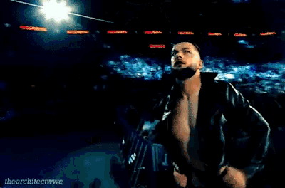 a man without a shirt is standing in front of a crowd with the word the on the bottom of the image