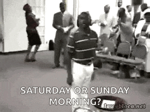 a man is standing in front of a crowd of people in a church and talking to them .