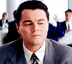 a close up of a man in a suit and tie making a funny face .