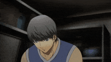 a man in a blue tank top is looking down in a dark room